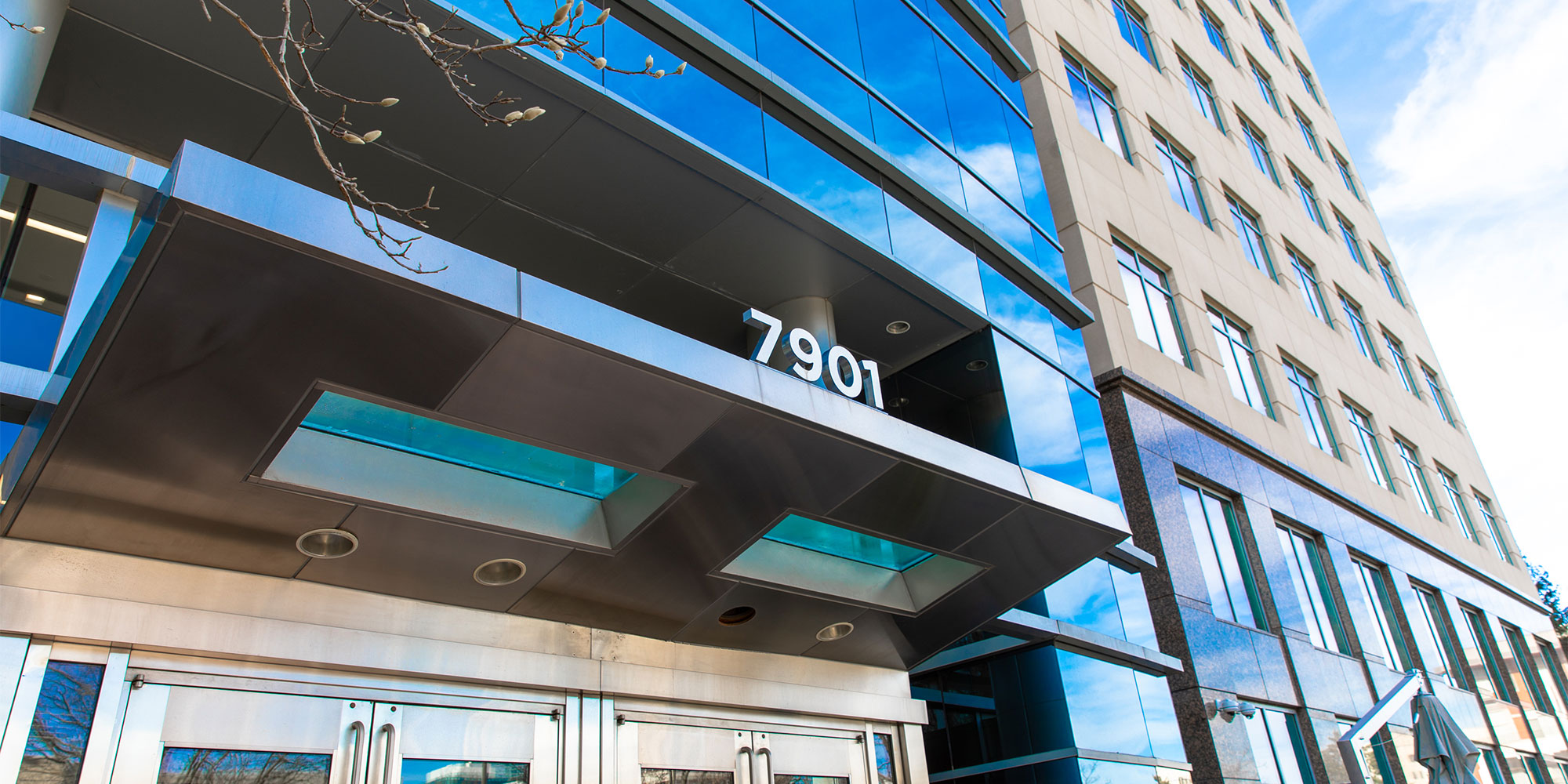 The glass entrance to the practice's building at 7901 Jones Branch Drive